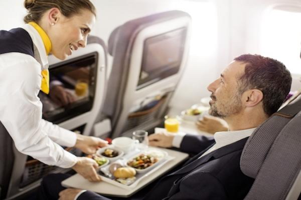 Stewardess presenting food to passenger